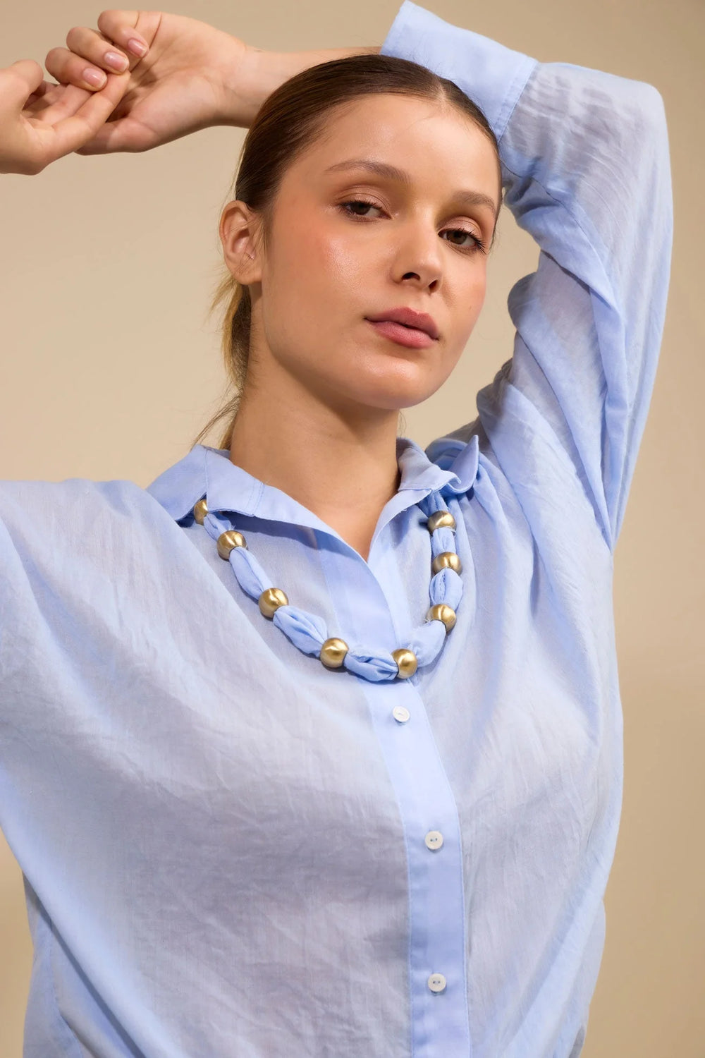 Collar Latido ANARIAS Atelier en tela blanca con bolas de bronce — vista frontal sobre modelo